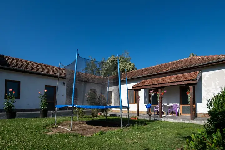 Батутът с предпазната мрежа на тревата