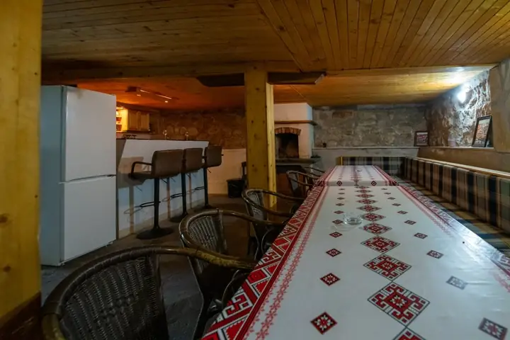 Механата от другия край на дългата маса, с плетените столове